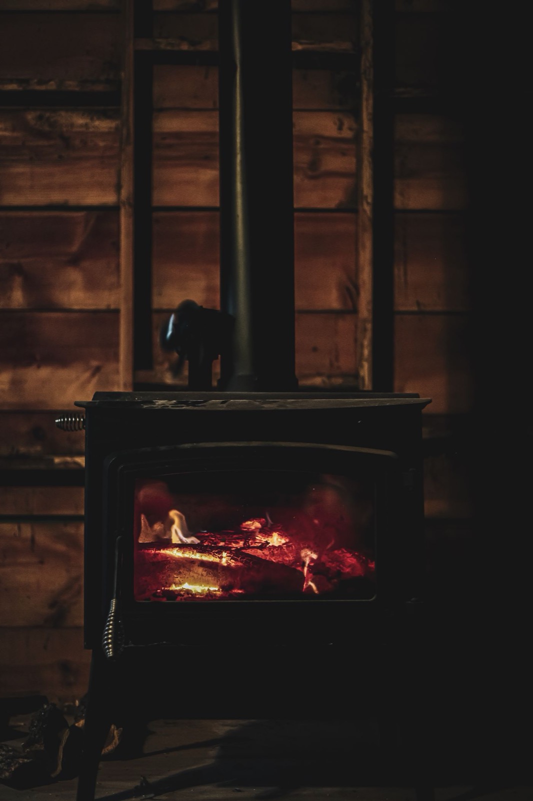 Poêle à bois aux braises rougeoyantes dans un intérieur chaleureux